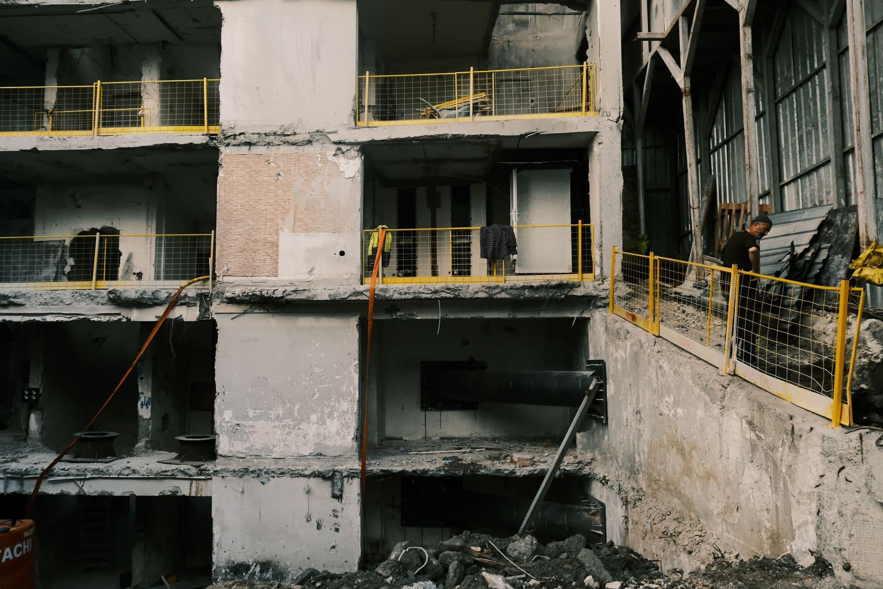 A multi-story concrete building with its walls removed, leaving floor slabs, columns and loose railings exposed.